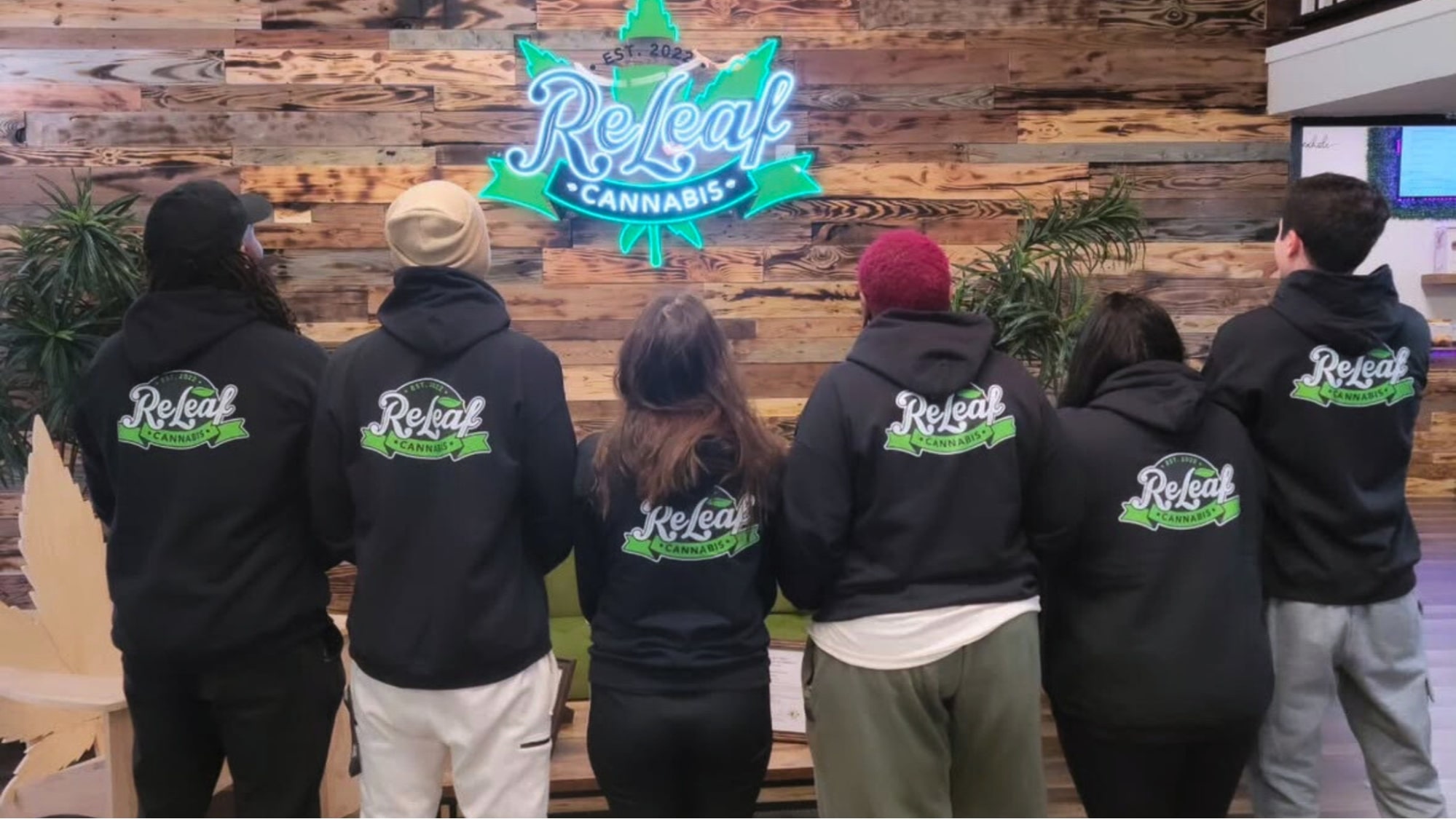 ReLeaf Cannabis employees wearing matching sweatshirts with ReLeaf Cannabis logo.