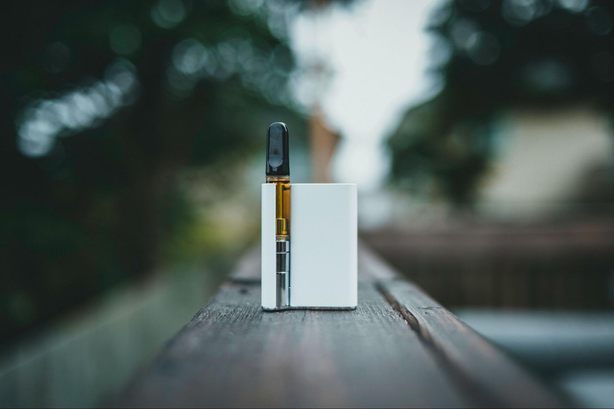 A vape placed on a wooden railing. Source - Pexels
